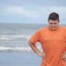 Obese kid on beach.